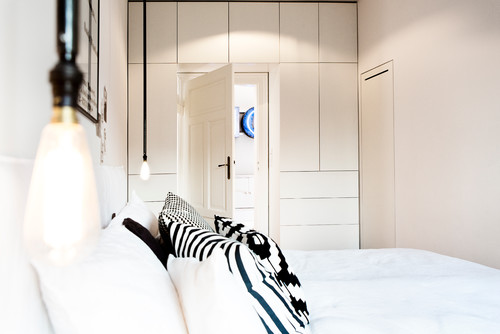 Helles Schlafzimmer mit deckenhohem Wandschrank, der viel Stauraum bietet, und ein halb offenes Ankleidezimmer bietet