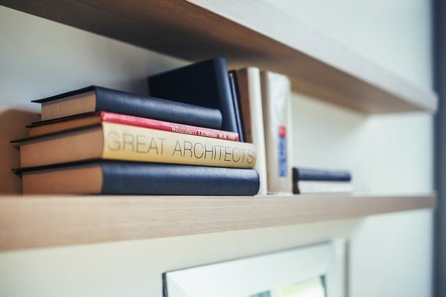 Nahaufnahme eines Bücherstapels mit der Aufschrift „GREAT ARCHITECTS“ auf einem Regal