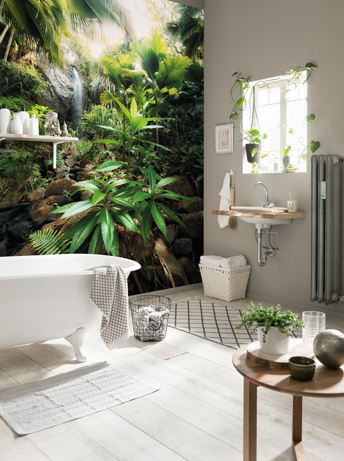Badezimmer mit weißer Badewanne und Dschungel-Fototapete mit Wasserfall an der Wand