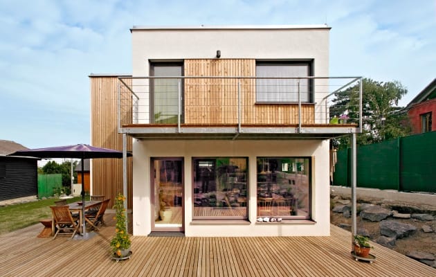 Modernes Kleingartenhaus mit heller Fassade, Holzverkleidung, Balkon und Holzterrasse