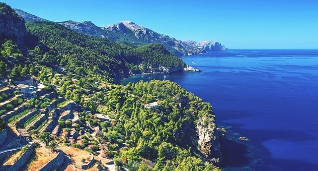 Luftbild der bewaldeten Küstenlinie von Mallorcas Westküste mit dem Mittelmeer und Bergkette