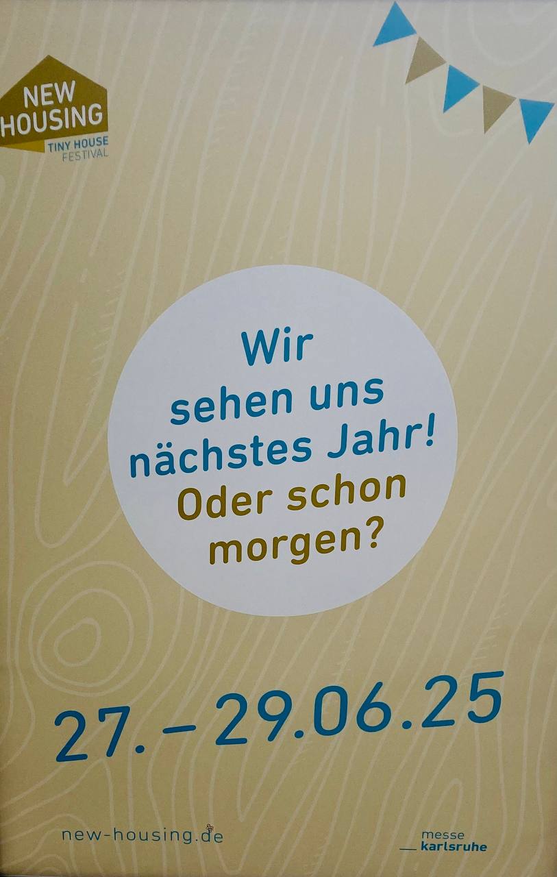 Werbeschild der New Housing Tiny House Festival Messe Karlsruhe mit dem Spruch „Wir sehen uns nächstes Jahr! Oder schon morge