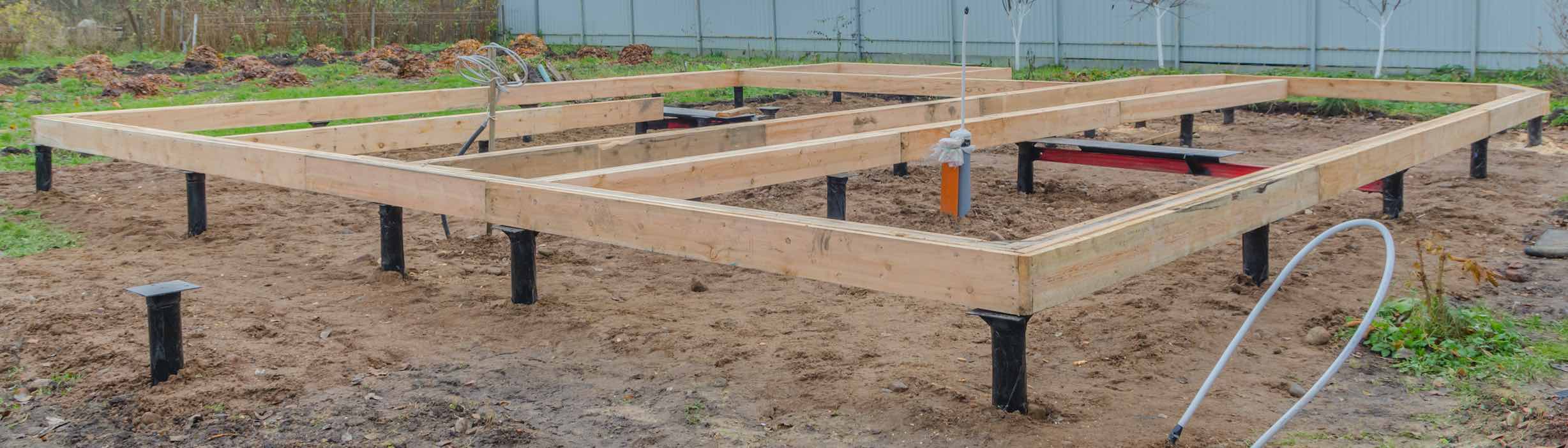 Unterkonstruktion aus Holzbalken auf Schraubfundamenten im Erdreich für ein Minihaus