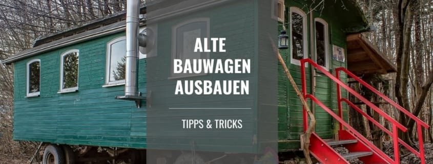 Grüner Bauwagen mit roter Holztreppe und Schornstein steht im Wald, Titelbild des Artikels