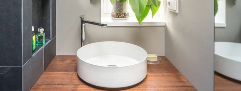 Ein Waschbecken mit Wasserhahn und Seife in einem kleinen barrierefreien Badezimmer