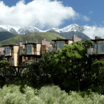 Baumhaus-Suiten der Hapuku Lodge in Kaikoura, dahinter schneebedeckte Berge