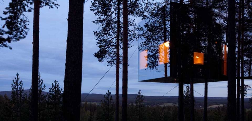 Verspiegeltes Baumhaus im Wald, Fenster leuchten orange (Foto: Peter Lundstrom, WDO)