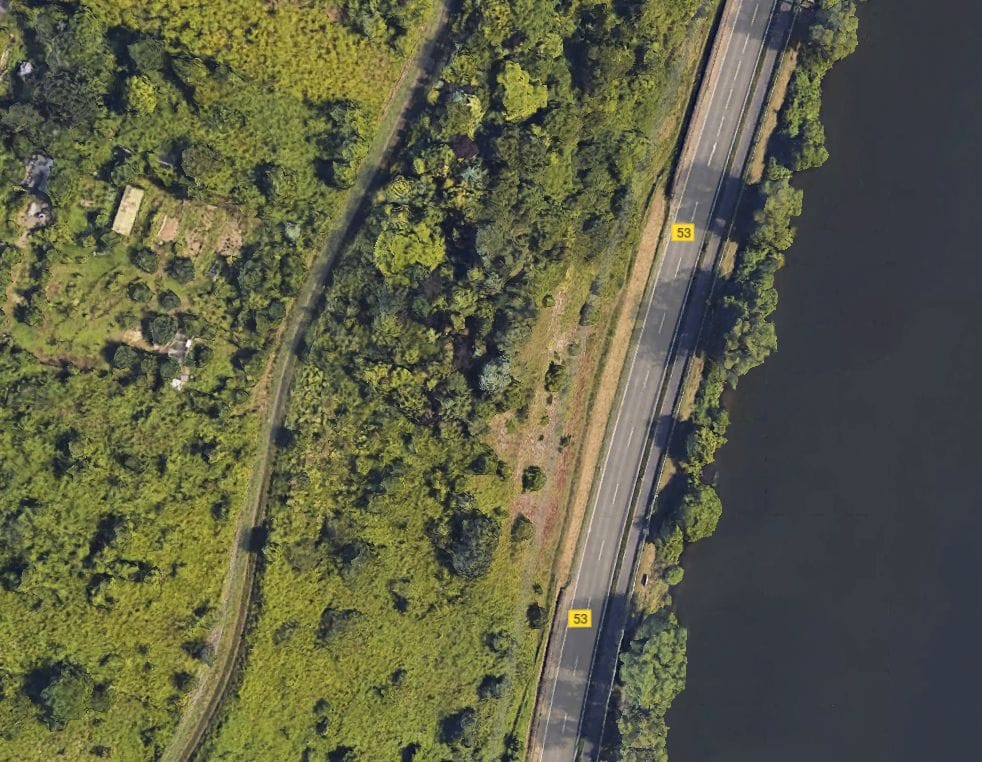 Luftaufnahme eines Waldstücks mit der Mosel, der Bundesstraße 53 und einem möglichen Baugrundstück in Traben-Trarbach