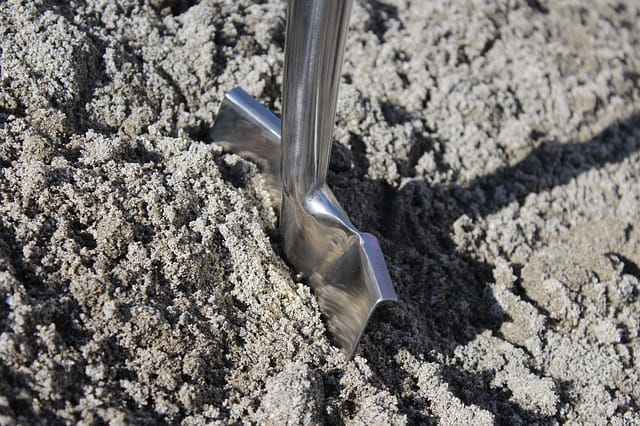 Spaten in einem Berg aus Sand