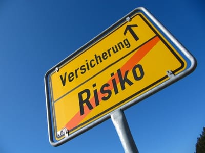 Ortsschild mit der Aufschrift „Versicherung“ und einem durchgestrichenen „Risiko“