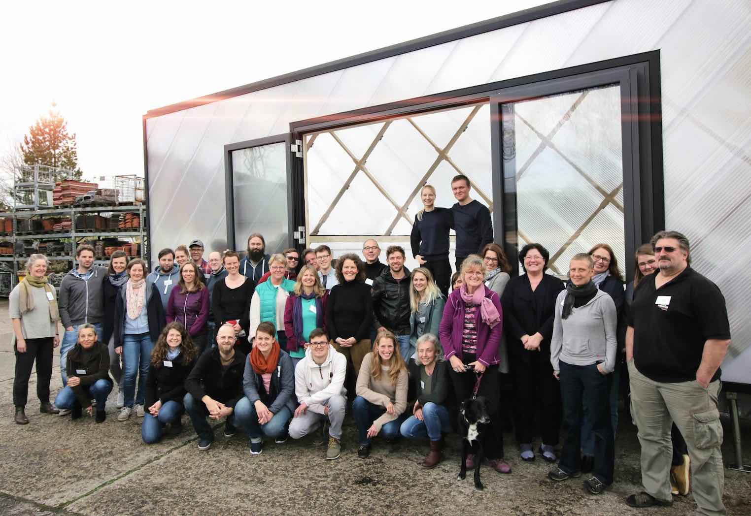 Menschen sitzen in einem Tiny-House-Workshop und lernen interessiert Grundlagen zur Planung und zum Bau.
